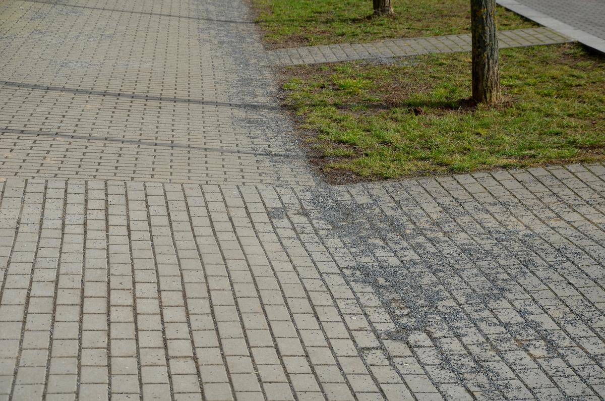 Posyp náledí na chodníku, který je třeba po zimě uklidit a zamést